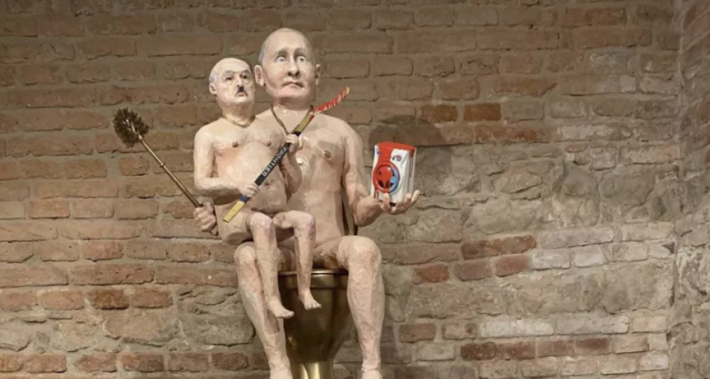 O sculptură cu Putin gol stând pe WC și cu Lukașenko în brațe, scoasă la licitație pentru a cumpăra o dronă